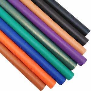 以下が含まれることがあります： さまざまな色の人工皮革のロールシートの詰め合わせ。茶色、オレンジ、青、緑、紫、黒などの色が含まれます。シートは斜めに配置されており、素材のさまざまな色合いと質感を表現しています。