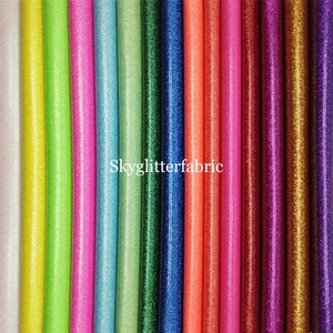 May include: A collection of 15 different colours of glitter fabric, each with a unique sparkle. The fabric is shown in strips, with the colours ranging from white to gold.