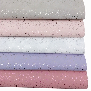 Op de afbeelding: Vijf stukken kunstleer met een zilveren glitterspikkels patroon. De stof is te zien in vijf kleuren: grijs, roze, wit, lavendel en roze.