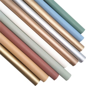May include: Assortment of metallic wrapping paper rolls in various colours, including gold, silver, white, and shades of green and brown.