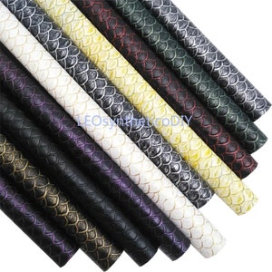May include: Assortment of faux leather sheets with a textured snake skin pattern in various colours, including black, white, gold, purple, green, and red.