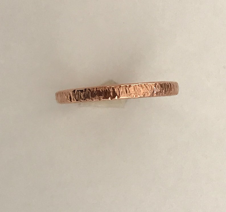 Pu&ograve; includere: Un anello in rame martellato con una superficie strutturata. L'anello ha un semplice design a fascia e un caldo colore marrone-rossastro. Questo gioiello &egrave; adatto all'uso quotidiano.