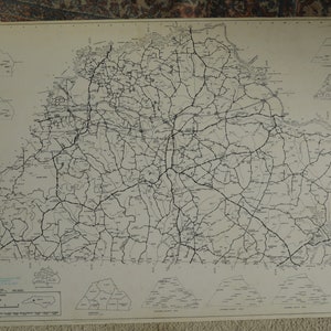 May include: A vintage map of North Carolina, featuring a detailed road network in black lines against a light background. The map includes county outlines and inset maps, with text at the bottom indicating the map's origin and scale.
