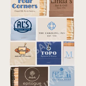 Może przedstawiać: Kolekcja pudełek zapałek z r&oacute;żnymi logo i tekstem. Pudełka zapałek zawierają projekty dla "Four Corners", "Linda's Bar & Grill", "AL's Burger Shack", "The Carolina Inn", "Sutton's", "TOPO Restaurant & Brewery", "M", "epilogue" i "Carolina Coffee Shop".