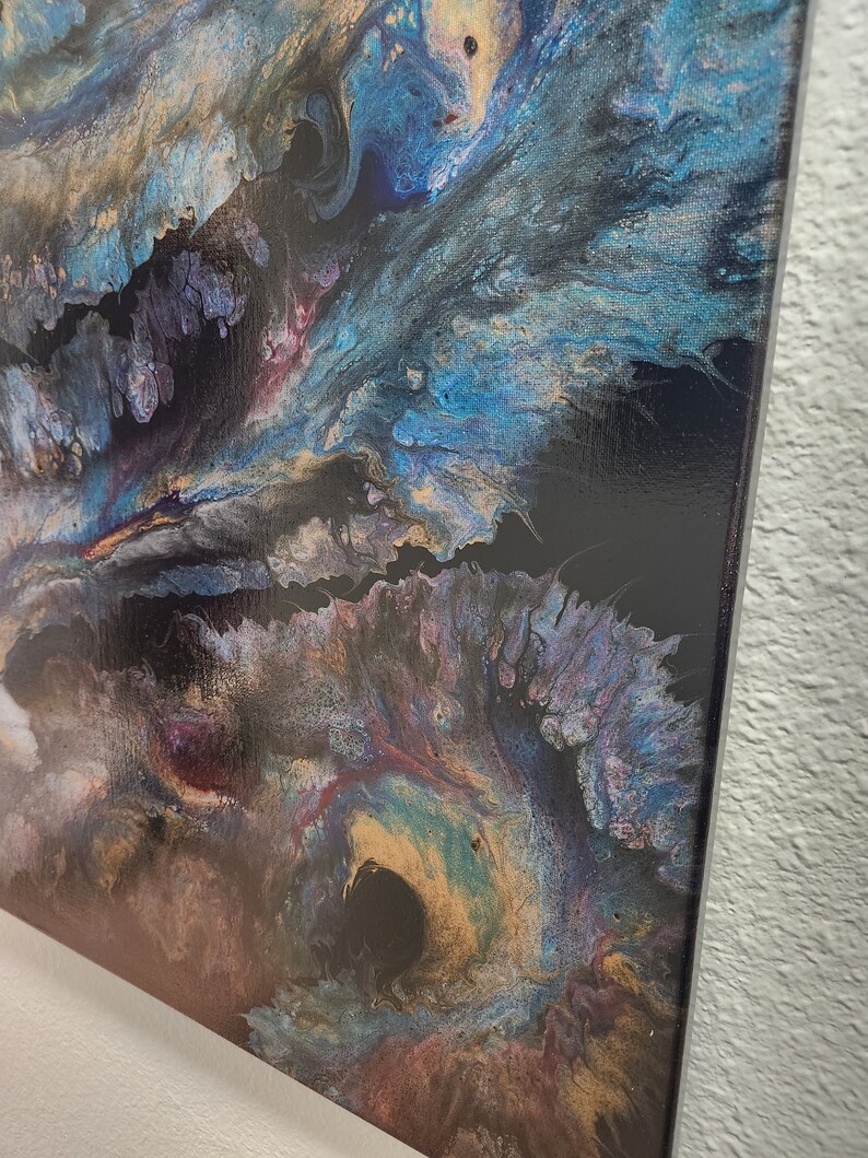 K&ouml;nnte beinhalten: Abstraktes Gem&auml;lde auf Leinwand mit wirbelnden blauen, goldenen und violetten Farben auf schwarzem Hintergrund.
