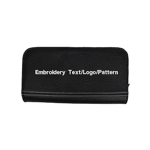 May include: A black rectangular wallet with a textured surface and rounded corners. The wallet features a horizontal line of white stitching near the bottom edge and the white text Embroidery Text/Logo/Pattern centered on the front face.