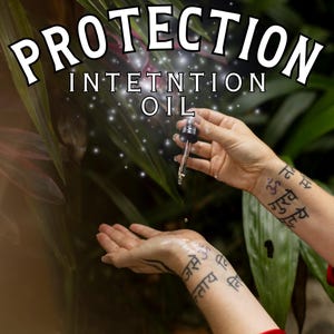 May include: A hand holds a dropper bottle labeled "Protection Intention Oil" over another hand with a tattoo in Sanskrit. The background is a blurred image of green foliage.