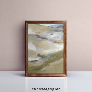May include: Abstract landscape painting in a brown wooden frame. The artwork features a blend of beige, gray, and green hues, evoking a sense of nature. The bottom of the frame rests on a white surface, with the text "curatedpapier" at the bottom.