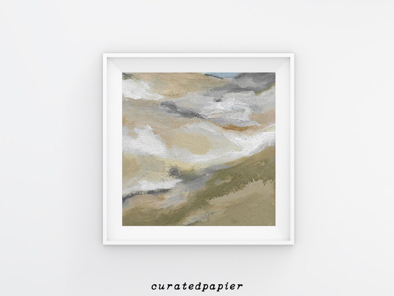 May include: Abstract art print in a white frame. The artwork features a landscape-inspired design with beige, white, gray, and olive green brushstrokes. The text "curatedpapier" is printed in black at the bottom of the frame.