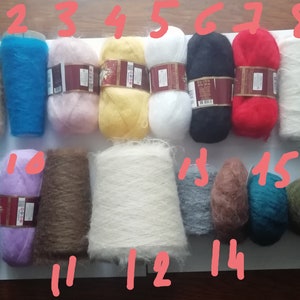 Pu&ograve; includere: Sedici gomitoli di filato soffice in vari colori tra cui beige, blu, rosa, giallo, bianco, nero, rosso, azzurro, viola, marrone, grigio e verde scuro, ognuno contrassegnato da un numero da uno a sedici scritto con inchiostro rosso sull'immagine.