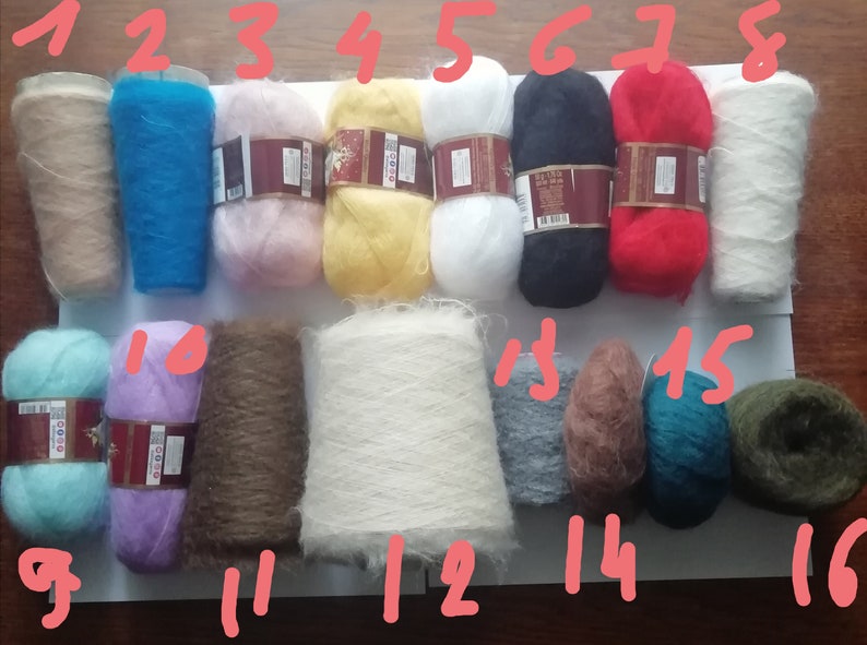 Pu&ograve; includere: Sedici gomitoli di filato soffice in vari colori tra cui beige, blu, rosa, giallo, bianco, nero, rosso, azzurro, viola, marrone, grigio e verde scuro, ognuno contrassegnato da un numero da uno a sedici scritto con inchiostro rosso sull'immagine.