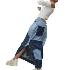 May include: Patchwork denim trousers with a high waist and a side zip. The trousers combine light and dark blue denim panels and have a relaxed fit. The model is wearing white platform trainers and a white long-sleeved top.