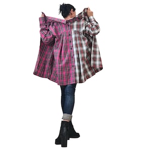May include: A two-tone plaid shirt in pink and red, with a button-down front and long sleeves. The shirt is worn with blue jeans and black boots. The plaid pattern is a classic design, suitable for casual wear.