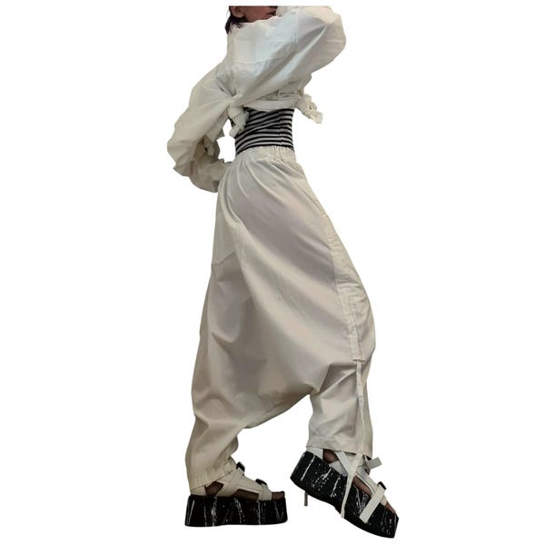 Conjunto veraniego extravagante de algodón blanco, top asimétrico y pantalones bombachos holgados.