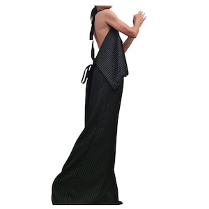 May include: A black and white striped halter dress with a flowing skirt. The dress has a low back and ties at the neck and waist. The fabric has a subtle pinstripe pattern, creating a sophisticated and elegant look.