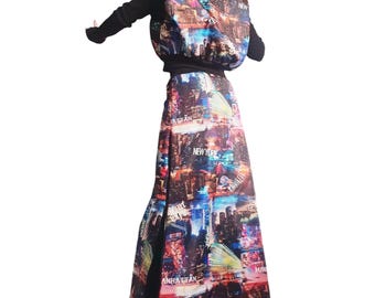 May include: A long-sleeved jacket and a matching floor-length skirt featuring a vibrant, multi-colored New York City skyline print. The fabric displays various city scenes with text including New York, Manhattan, and Bronx in white lettering.