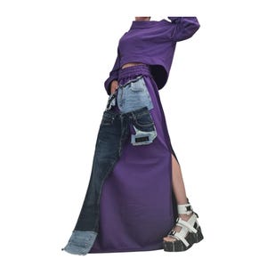 Puede incluir: Conjunto de dos piezas morado, compuesto por un top corto de manga larga y una falda larga con abertura. La falda está adornada con parches de mezclilla. Se completa con sandalias de plataforma blancas con detalles negros.