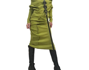 May include: An olive green dress with an off-the-shoulder design and long sleeves. The dress has a diagonal zip and is paired with a black leather necklace. The model is wearing black platform boots.