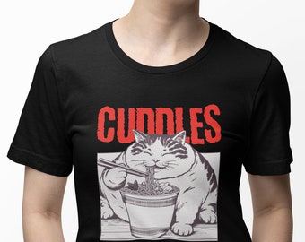 May include: Black t-shirt with a white cartoon cat eating noodles from a bowl. The text "CUDDLES AND CARBS" is printed in red on the shirt.