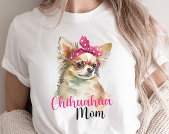 May include: White t-shirt with a watercolor illustration of a chihuahua wearing pink glasses and a pink polka dot headband. The text "Chihuahua Mom" is printed below the dog.