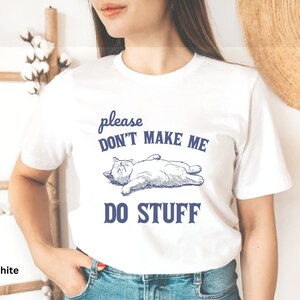May include: White t-shirt with a blue graphic of a cat sleeping and the text "please don't make me do stuff".