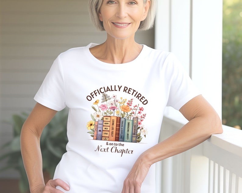 May include: White t-shirt with the text "Officially Retired & on to the Next Chapter" printed on it. The text is surrounded by a stack of books and colorful flowers.