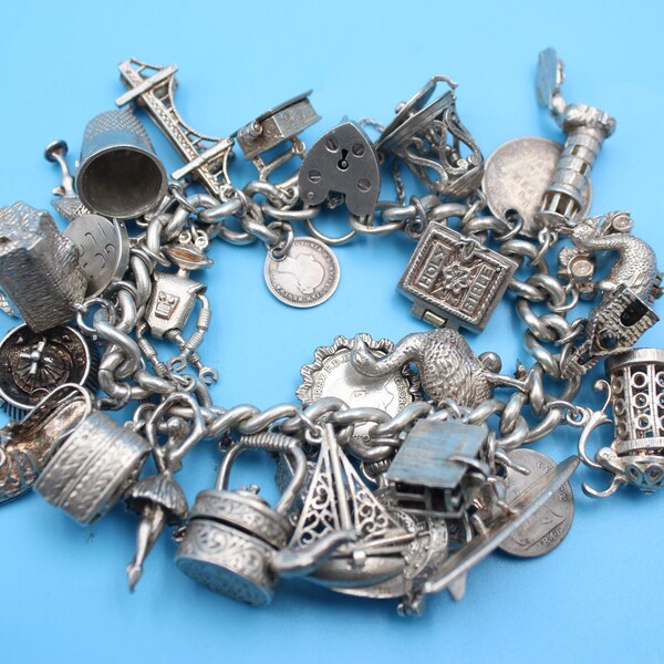 Exceptional 1970s sterling silver charm bracelet with 28 silver charms including opening charms, coins, animals, Smash robot