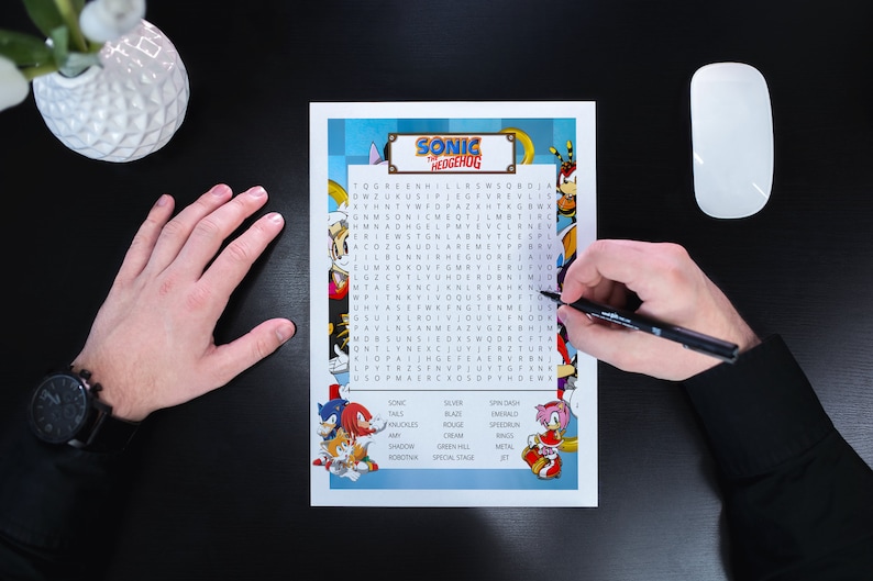 Op de afbeelding: Een blauwe en witte woordzoeker met personages uit de Sonic the Hedgehog-videogameserie. De puzzel bevat woorden als Sonic, Tails, Knuckles, Amy, Shadow en Robotnik.
