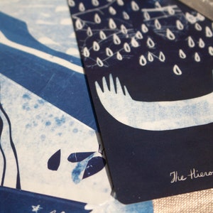 May include: Two tarot cards with indigo and white illustrations. One card features a waterfall design, and the other depicts a stylized image of hands with raindrops. The text "The Hierophant V" is visible on the second card.