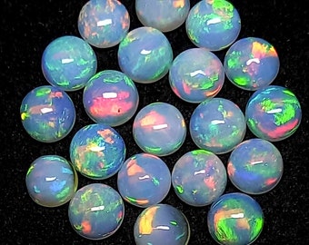 May include: A collection of 18 iridescent opal cabochons, each with a unique pattern of color and light. The cabochons are round and have a smooth, polished surface. They are a beautiful and versatile gemstone that can be used in a variety of jewelry designs.