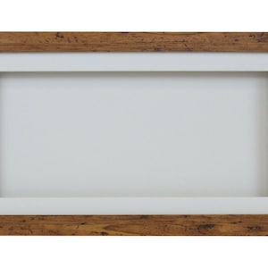 May include: A rustic brown wooden picture frame with a white mount. The frame has a distressed look and is perfect for displaying photos or artwork.