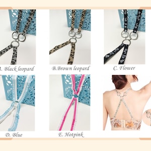 May include: Five different bra strap converters with different patterns. The patterns include black leopard, brown leopard, flower, blue, and hot pink. The converters are made of fabric and have metal rings.