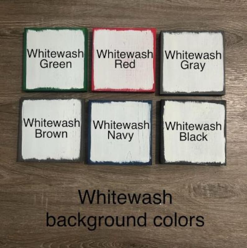 Op de afbeelding: Zes kleine, vierkante houten blokken met witgekalkte centra en gekleurde randen. De blokken zijn gelabeld met de tekst "Whitewash" gevolgd door de kleuren: Groen, Rood, Grijs, Bruin, Marine en Zwart. De tekst "Whitewash background colors" staat eronder.