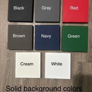 Op de afbeelding: Een verzameling vierkante kleurstalen in zwart, grijs, rood, bruin, marineblauw, groen, cr&egrave;me en wit. Elke staal heeft een bijbehorende kleurnaam in witte tekst. De afbeelding bevat ook de tekst "Effen achtergrondkleuren & letterkleuren."