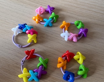 Può includere: Cinque elastici per capelli colorati con dettagli a forma di stella in vari colori, tra cui rosa, viola, verde, arancione, blu, giallo e rosso. Ogni elastico presenta un elastico color lavanda. Questi accessori sono perfetti per aggiungere un tocco di colore a qualsiasi acconciatura.