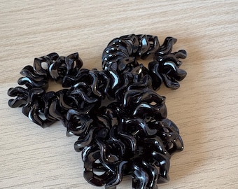 Può includere: Diversi elastici per capelli neri a spirale sono disposti su una superficie di legno chiaro. Gli elastici per capelli hanno una finitura lucida e un design a spirale, adatti a vari tipi di acconciatura. Un accessorio per capelli pratico ed elegante.