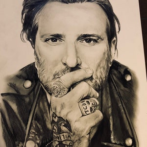 May include: Black and white drawing of a man with a beard and a leather jacket. He is wearing a ring with the letters "TCB" on it and has a tattoo of an anchor on his hand with the word "WILMAR" written above it.