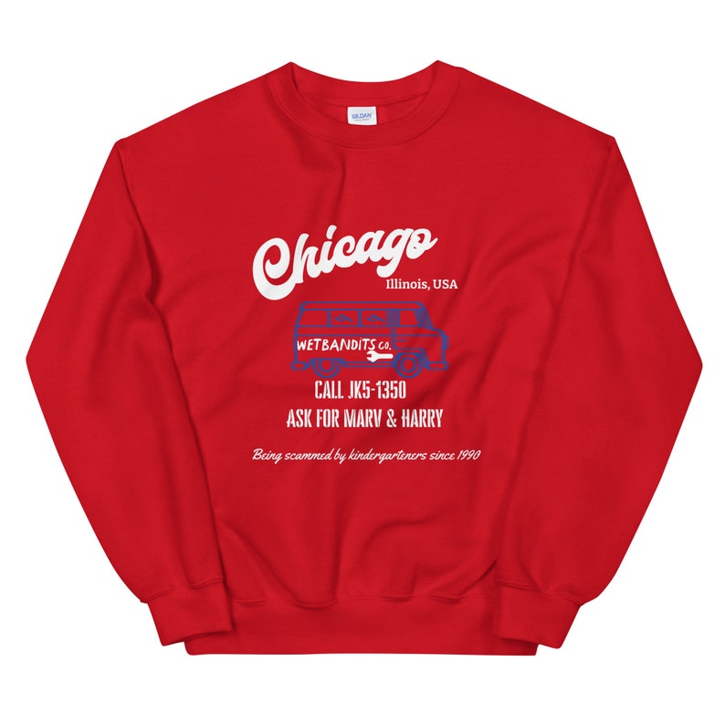May include: A red sweatshirt with the word "Chicago" in white script. Below, a blue and white graphic of a van with the text "WETBANDITS.CO." and a phone number. The text "ASK FOR MARV & HARRY" is also visible.