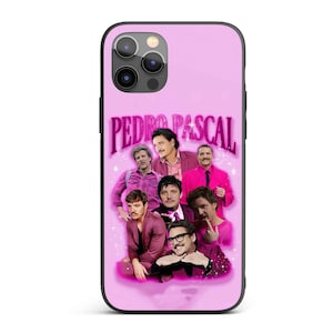 May include: A pink phone case with a black border, displaying a collage of images of Pedro Pascal. The name "PEDRO PASCAL" is written in a pink, stylized font. The images are arranged in a grid-like pattern.
