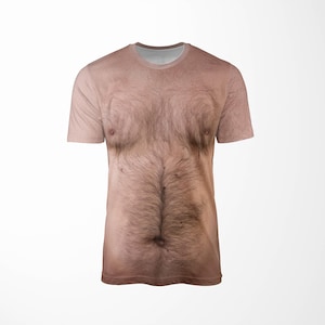 Puede incluir: Una camiseta de manga corta con una impresi&oacute;n realista de un pecho y torso peludo. La camiseta tiene cuello redondo y est&aacute; impresa con una imagen detallada de vello corporal, pezones y tonos de piel, creando un art&iacute;culo humor&iacute;stico.