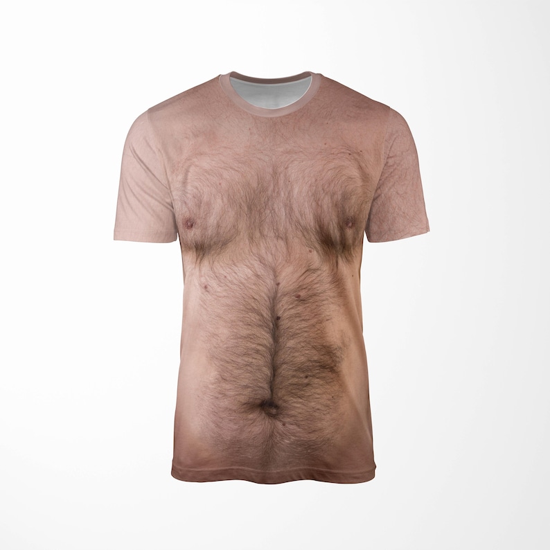 Puede incluir: Una camiseta de manga corta con una impresi&oacute;n realista de un pecho y torso peludo. La camiseta tiene cuello redondo y est&aacute; impresa con una imagen detallada de vello corporal, pezones y tonos de piel, creando un art&iacute;culo humor&iacute;stico.