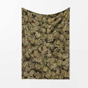 May include: A green and brown fabric blanket with a pattern of dried cannabis buds.