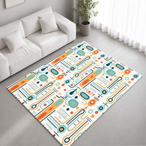 May include: A rectangular area rug featuring a repeating geometric pattern of orange, teal, and dark blue shapes on a white background. The design consists of elongated capsules, circles, and thin parallel lines arranged in a structured layout.