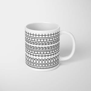 May include: White ceramic mug with a black geometric pattern. The design includes horizontal bands of lines, squares, and wave-like shapes. The mug has a curved handle and is on a white background.