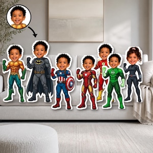 May include: A collection of seven die-cut cardboard or foam board standees featuring a young child's face superimposed onto various superhero bodies, including Aquaman, Batman, Captain America, Iron Man, The Flash, Green Lantern, and Black Widow.