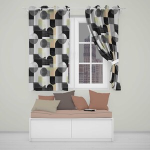 May include: Two window curtains featuring a geometric pattern of black, grey, and beige circles and semicircles. Below the window sits a white storage bench with a light pink cushion and four throw pillows in shades of beige, grey, and pink.