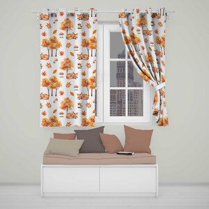 May include: White curtains featuring a repeating pattern of orange foxes, yellow and orange autumn trees, and small mushrooms. The curtains are hung on a silver rod with grommets, covering a window that looks out onto a city skyline.