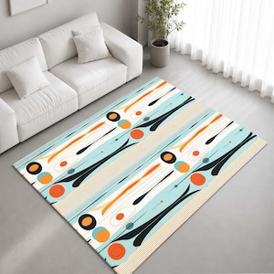May include: A rectangular area rug featuring a light blue background with a repeating pattern of black curved shapes, orange circles, and thin tan parallel lines. The design includes scattered small dots and white oval accents across the surface.
