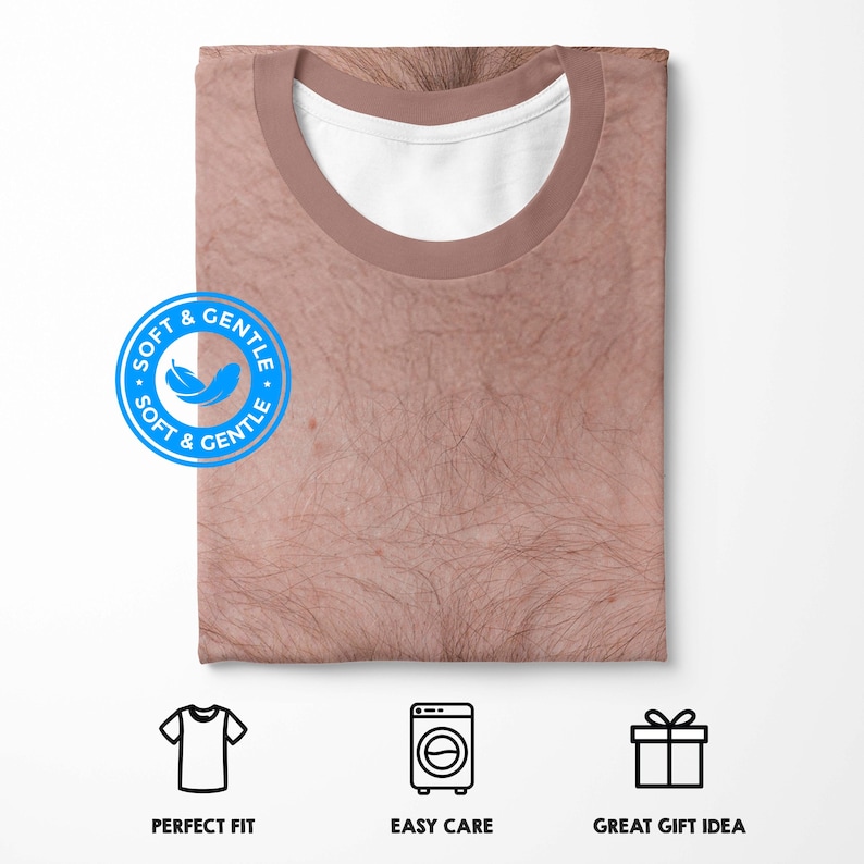 Puede incluir: Una camiseta doblada con un estampado realista de un pecho peludo. La camiseta tiene un cuello marr&oacute;n y un cuello interior blanco. La imagen incluye iconos de ajuste perfecto, f&aacute;cil cuidado y gran idea de regalo.