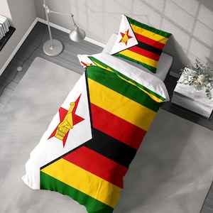May include: A duvet cover and pillowcase set with the flag of Zimbabwe design. The bedding features green, yellow, red, and black stripes, a white triangle with a red star, and a bird emblem. The set is on a white bed.